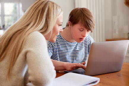 Two people working on a laptop